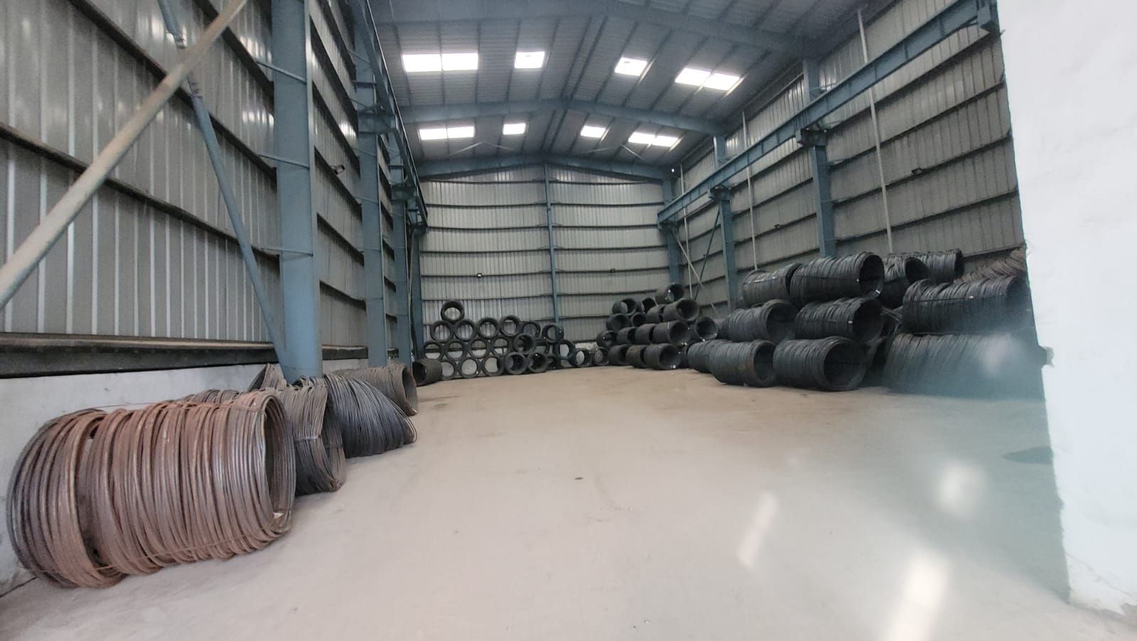 Wire rod coils stacked along both sides of the warehouse at Plot 213, IMT Faridabad